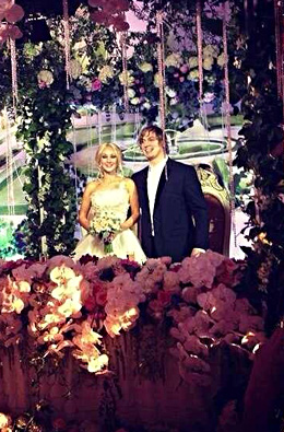 Стол молодых украшен белыми орхидеями, а молодожены сидели на позолоченных тронах