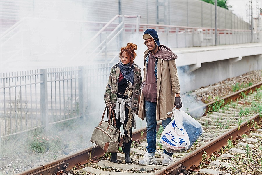 Певица и ее партнер блестяще перевоплотились в бездомных, шедших куда-то по железнодорожным путям.