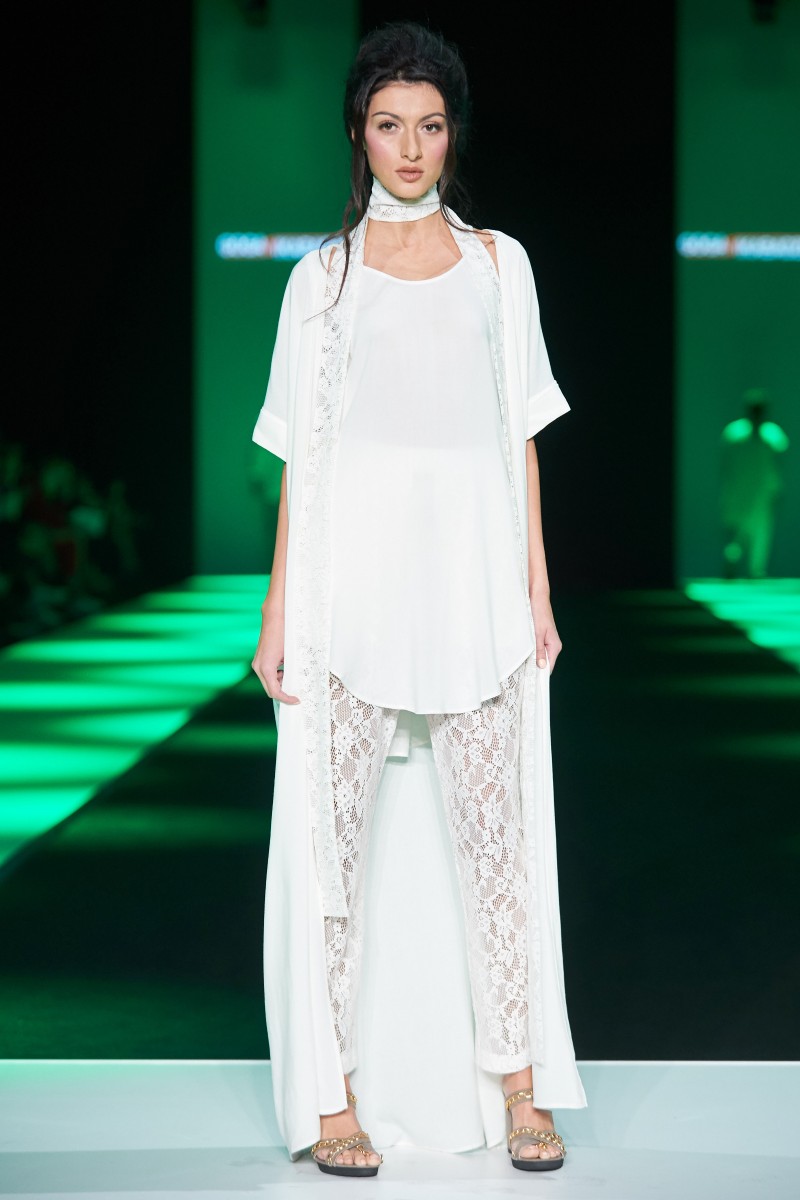 Платья со струящимися свободными рукавами, брючные комбинезоны, кружевные топы, шелковые накидки для женщин. Удлиненные туники, вязаные джемпера, рубашки с жилетами – для мужчин. Закрыла показ олд-модель в закрытом черном платье с книгой с надписью Love story. GOGA NIKABADZE.