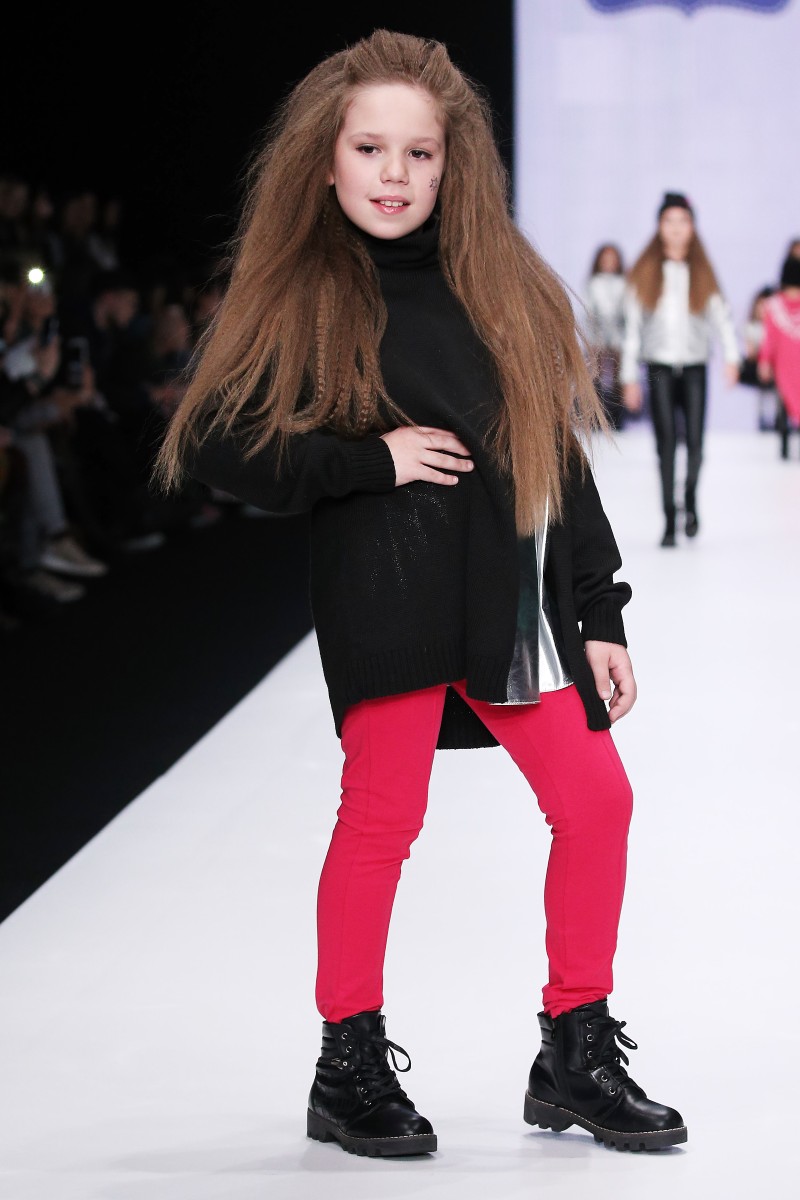 Летние блузы, комбинезоны и платья в бирюзовом, розовом и желтом цветах. Главный декоративный элемент второй части показа – цветы. В завершении показа – линия праздничных платьев для детей. L'EDERE.