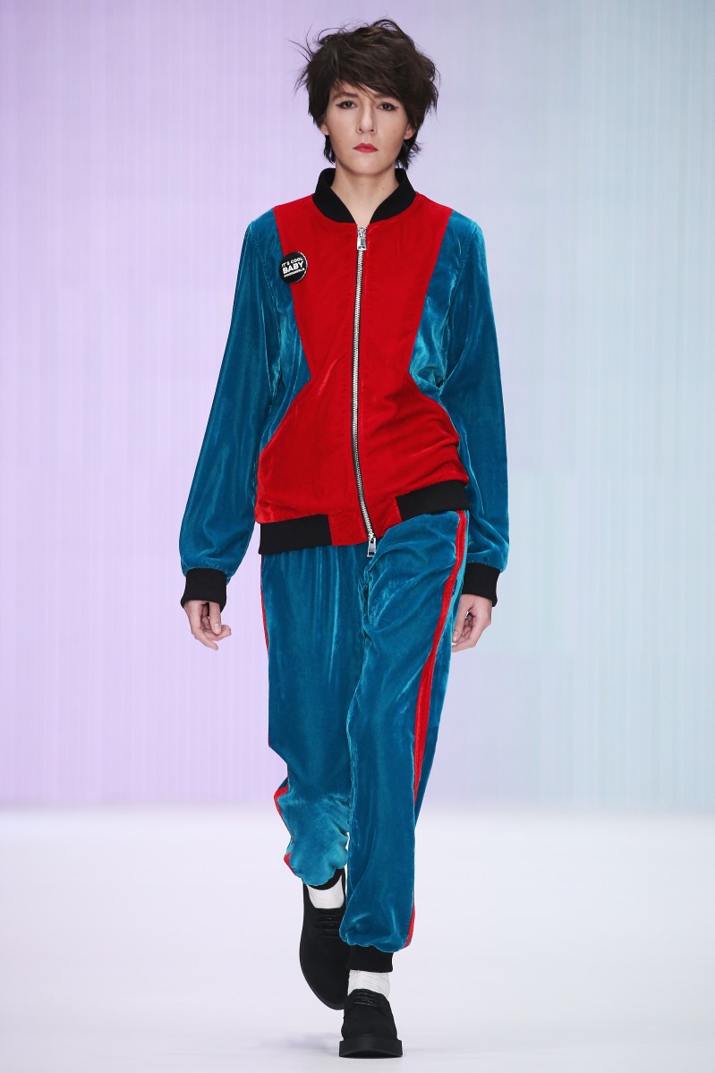 Часть коллекции нового сезона выполнена в стиле спорт-шик: толстовки и футболки он смешивает с юбками из серебристой и золотой экокожи. Мужские спортивные костюмы из красного бархата и футболки с кожаными рукавами. Полоска и шотландская клетка дополняется яркими поясами-бантами. VADIM MERLIS.