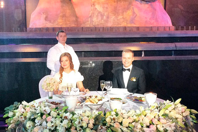 Стол счастливых новобрачных был украшен охапками белых роз и лилий